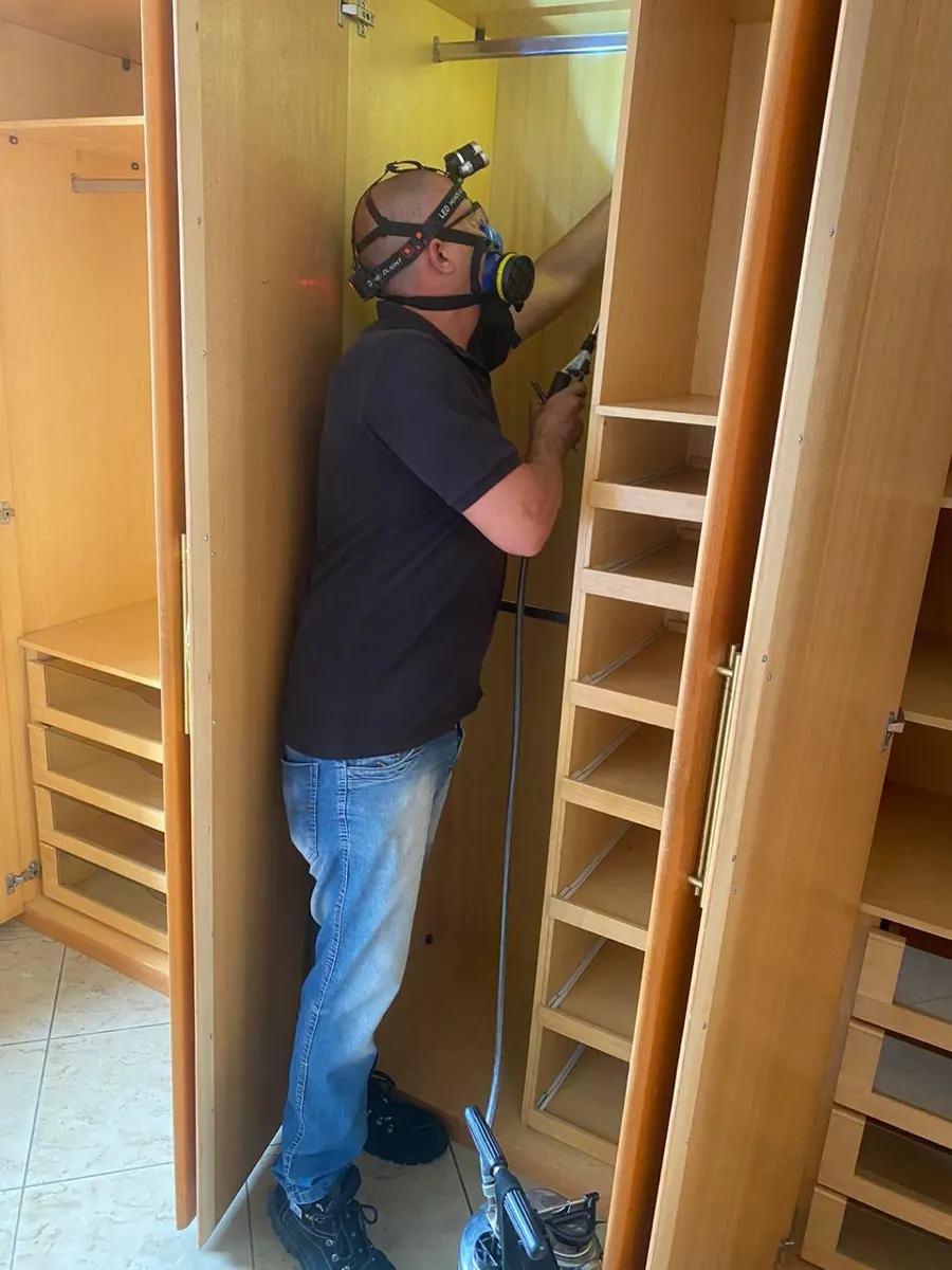 Técnico da Naoki tratando armário de madeira com equipamento de injeção