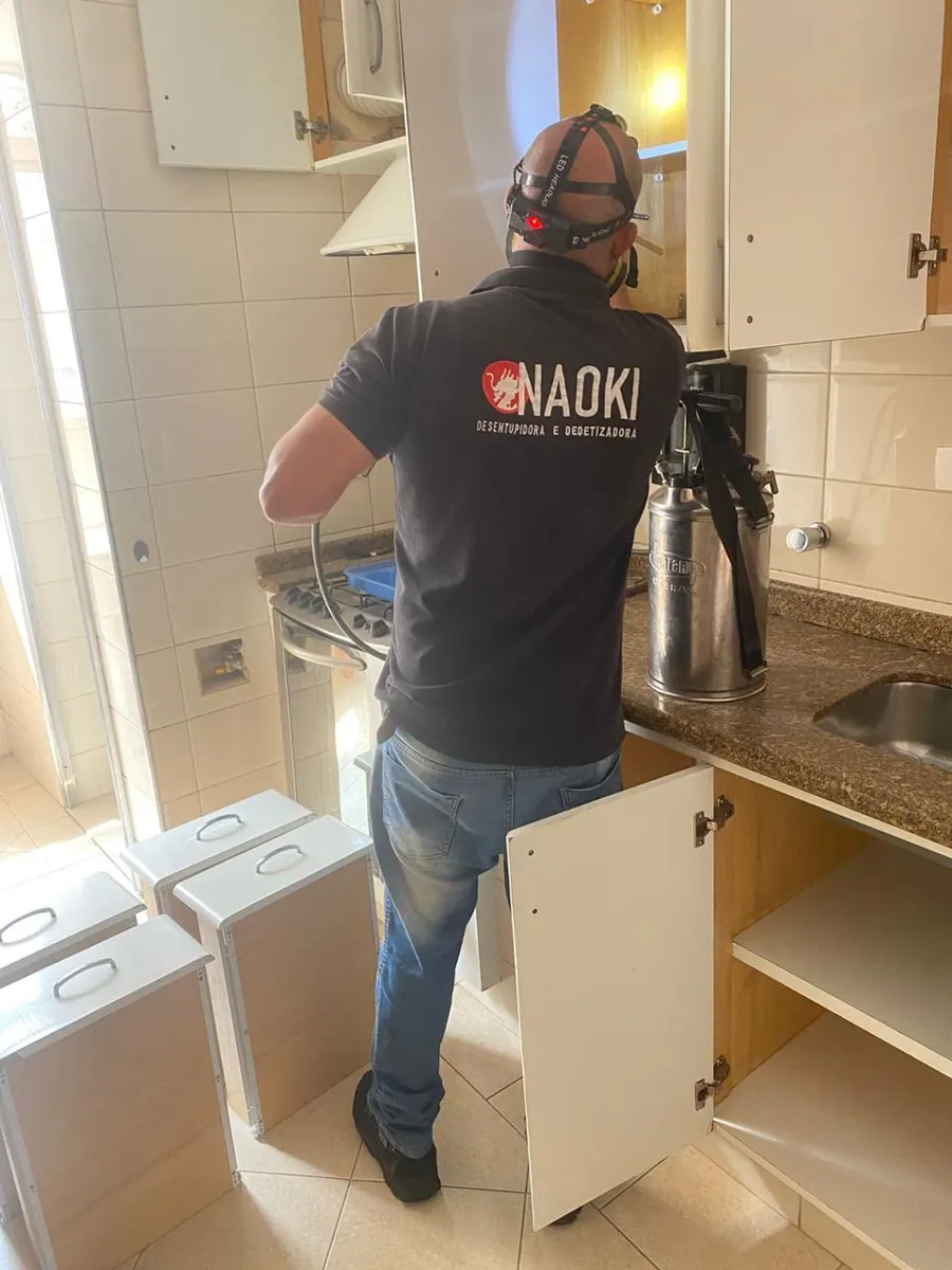 Técnico da Naoki aplicando tratamento em armários de cozinha em São Paulo